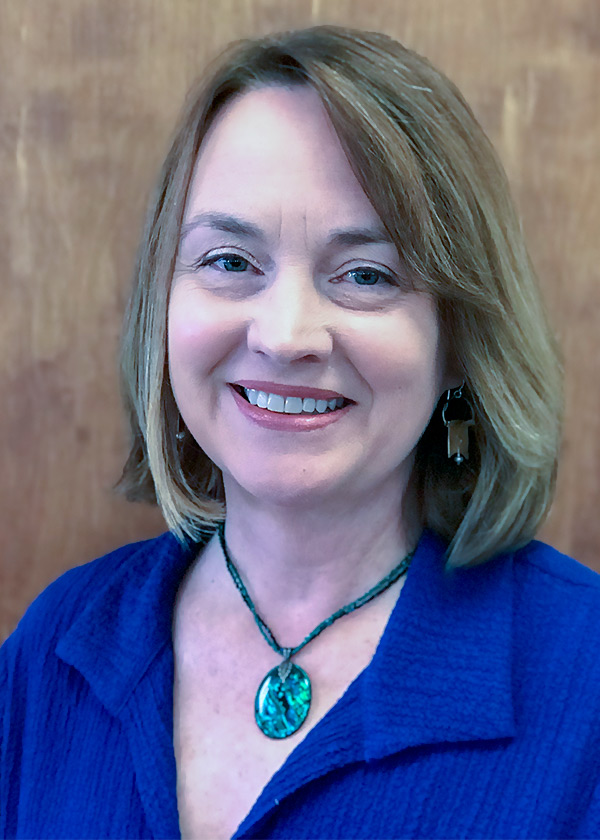 Maureen Vanacore in a blue dress, panelled wood background